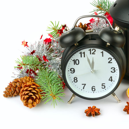 New Year and Christmas decor: retro alarm clock, spruce branch and shiny decorations isolated on...