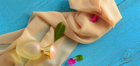 Silk scarf and perfume bottle on blue vintage background. wide photo.の写真素材