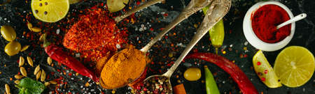 Many different spices and aromatic herbs on a dark table. View from above. Wide photo.の写真素材