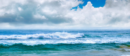 Tropical beach with high waves. Yellow warm sand and summer sea with sky and free space. wide photo.の写真素材