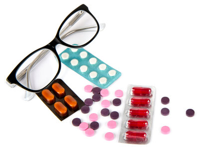 Glasses and medicine pills isolated on white background.の写真素材