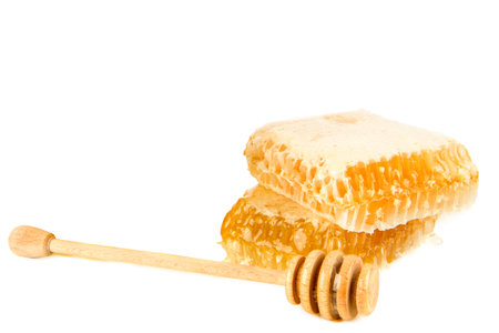Honey in honeycomb and dipper isolated on white background. Free space for text.の写真素材