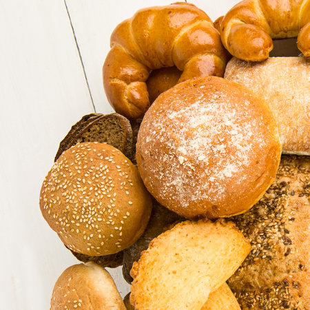 Bread, sweet buns and croissants on white background. Free space for text.の写真素材