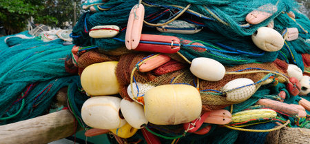 Fishing gear, nets, and floats are dried on the shore. Wide photo.の写真素材
