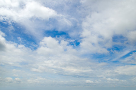 Blue bright sky with light, cumulus clouds.の写真素材
