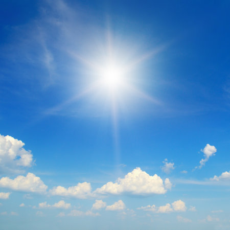 Blue sky with white clouds and bright sun.の写真素材