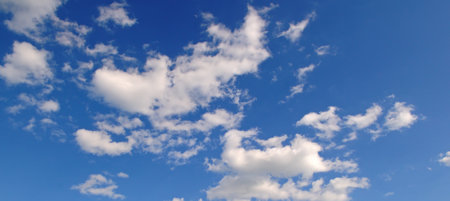 clear blue sky with a few clouds. The sky is very bright and the clouds are scattered throughout. Wide photo.の写真素材