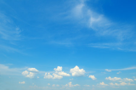 clear blue sky with a few clouds. The sky is very bright and the clouds are scattered throughout.の写真素材