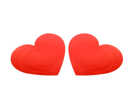 A striking image of two bright red paper hearts placed side by side, symbolizing love, romance, and partnership. The clean white background offers excellent copy space for text or graphic overlays.の写真素材