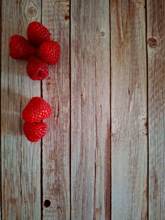 Raspberries on wooden background. Top view. Copy space.