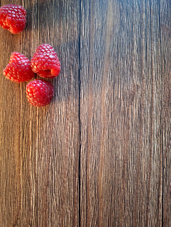 Ripe raspberries on wooden background. Top view with copy space