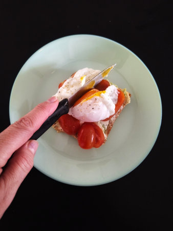 Toast with poached egg, tomatoes and cheese on a plate