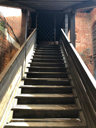 gray wooden staircase with railing going up