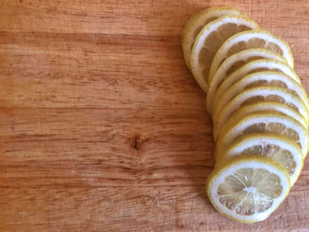 close up fresh lemon and slices lines on a wooden cutting boardの写真素材