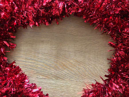 red tinsel on wooden backgroundの写真素材