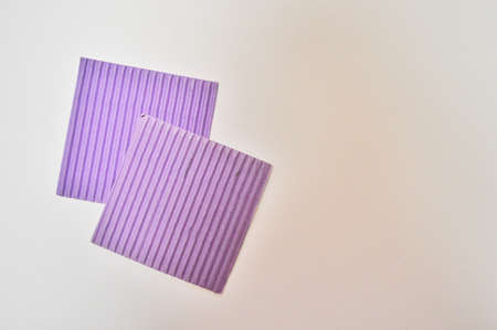 pink square pieces of paper on a white backgroundの写真素材