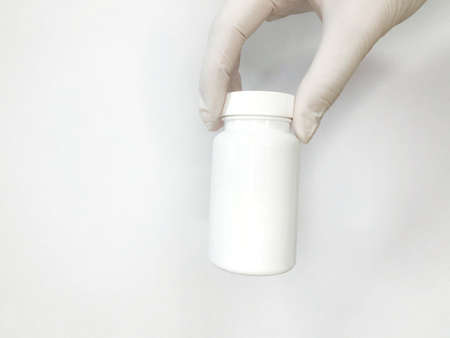 white glove with a white jar on a white backgroundの写真素材