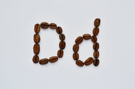 letters d made of coffee beans on the white background.