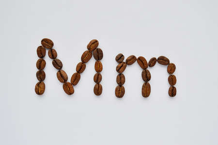 letters m made of coffee beans on the white background.の写真素材