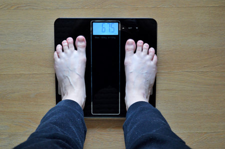 Lose weight concept with person on a scale measuring kilograms.