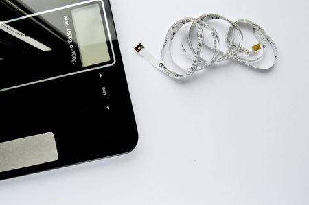 Dieting concept with scales and measuring tape on the white background