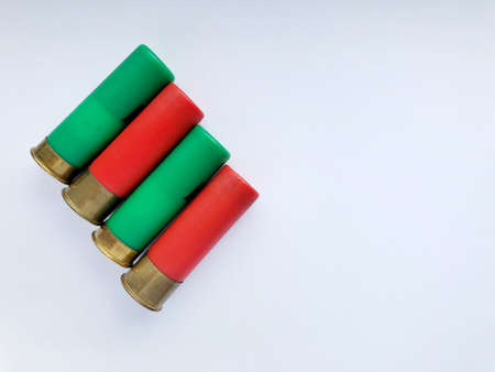 Several hunting cartridges and scattered pellets of cartridges isolated on a white background.の写真素材