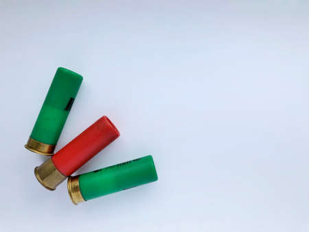 Several hunting cartridges and scattered pellets of cartridges isolated on a white background.の写真素材
