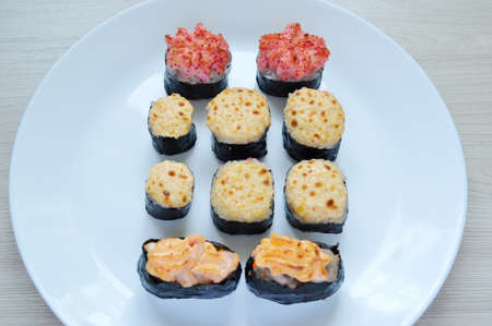 Sushi set on a white plate. Different baked rolls on a white plateの写真素材