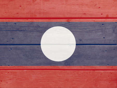 Lao P.D.R. flag painted on wood plank background. Brushed natural light knotted wooden board texture. Wooden texture background flag of Lao P.D.R.の写真素材