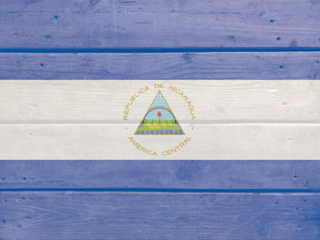 Nicaragua flag painted on wood plank background. Brushed natural light knotted wooden board texture. Wooden texture background flag of Nicaraguaの写真素材
