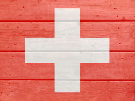 Switzerland flag painted on wood plank background. Brushed natural light knotted wooden board texture. Wooden texture background flag of Switzerlandの写真素材