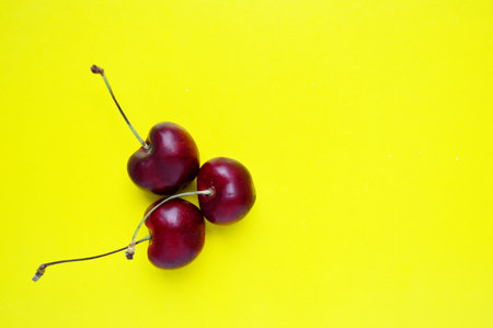 sweet cherry on a yellow background.の写真素材