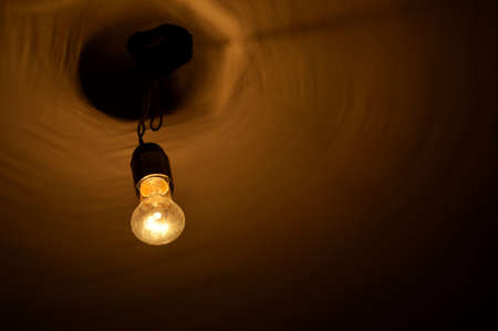 Old orange light bulb on the ceiling.の写真素材