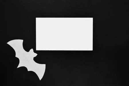 White paper bat lies on a black background with a white mockupの写真素材