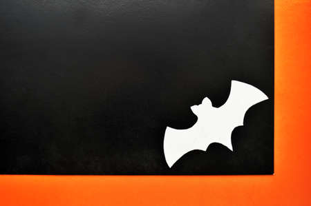 White paper bat lying on orange-black backgroundの写真素材