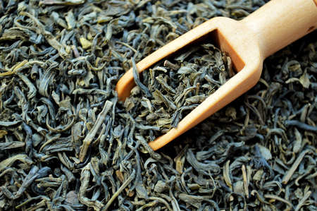 Wooden spoon lies in a heap of loose teaの写真素材