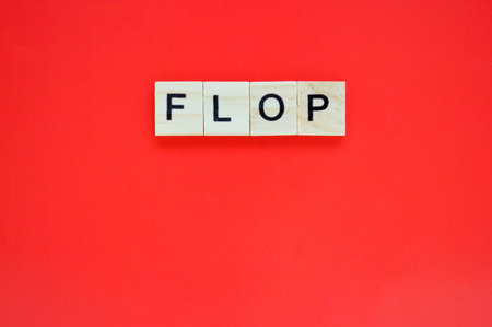 Word flop. Wooden blocks with lettering on top of red background. Top view of wooden blocks with...