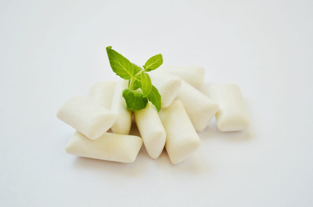 Bunch of fresh mint and gum pads on white background.