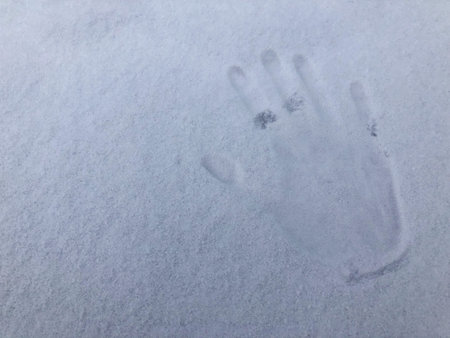 Handprint with fingers in white snow, background, texture.