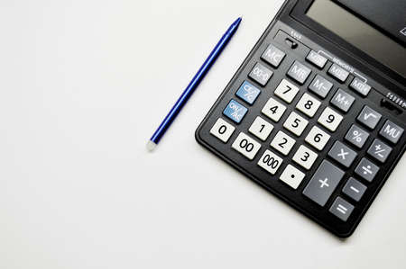Accountant's Day. Calculator and pen on white background with copy space.の写真素材