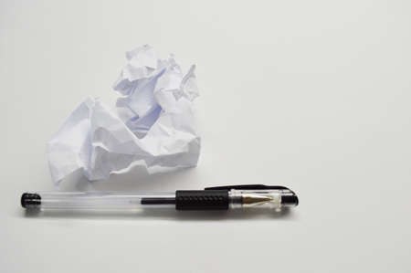 crumpled up paper wads and pen, isolated on white background. Writing concept.の写真素材