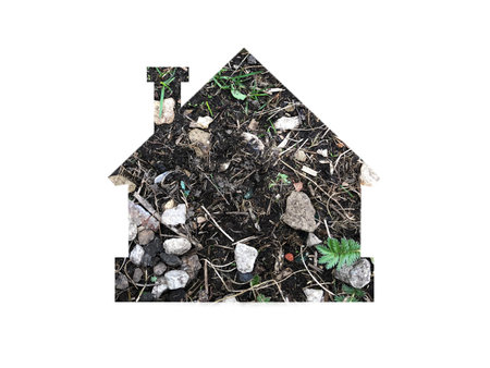 earth texture with stones and grass. Shot through the cut-out silhouette of the house