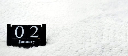 Wooden calendar from blocks on a white textile background with copy space. Banner. 2nd of January....
