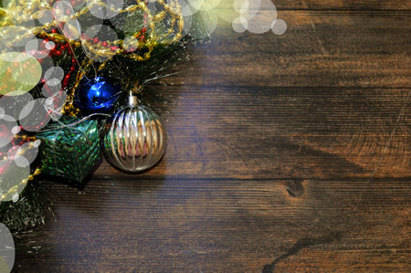 background of wood with fir branches, garland, gift, balls, red and gold beads