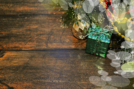 Christmas background of dark wood with fir branches,gift,ball,red and gold beads