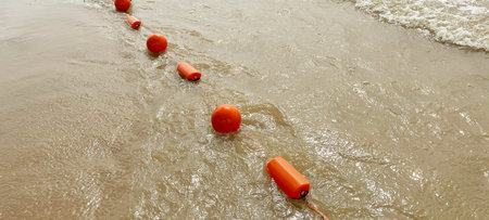 Bright orange plastic float washed up on the sandy shore. World Wetlands Day. International Day for Rivers. World Water Day. World Oceans Day. World Water Monitoringの写真素材