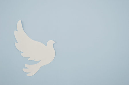 White paper origami bird on blue background. World Day of Peace. Day Against Humiliation. International Day Of Human Fraternity. International Day of Living Together in Peaceの写真素材