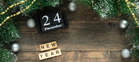word new year from wooden letters on a dark wooden background with fir branches and silver Christmas balls. Catholic Christmas Eve. Christmas Card Day. Bannerの写真素材