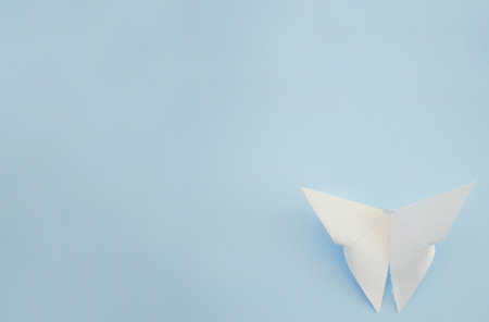 White paper origami butterfly on blue background. World Day of Peace. Day Against Humiliation. International Day Of Human Fraternity. International Day of Living Together in Peaceの写真素材