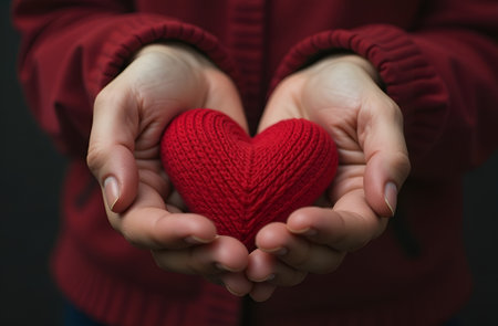Volumetric red knitted heart in hands. Valentine's Day. Mother's Dayの素材